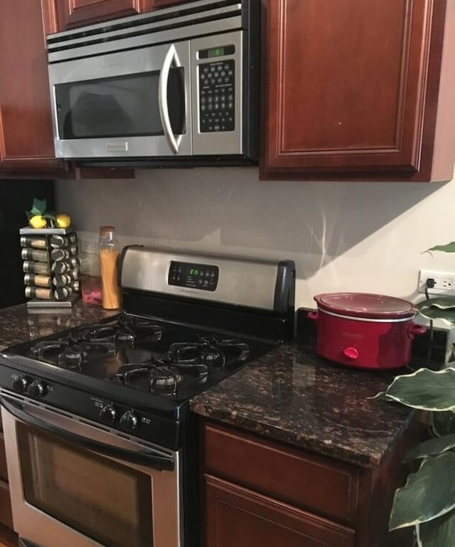 kitchen featuring dark stone countertops and stainless steel appliances