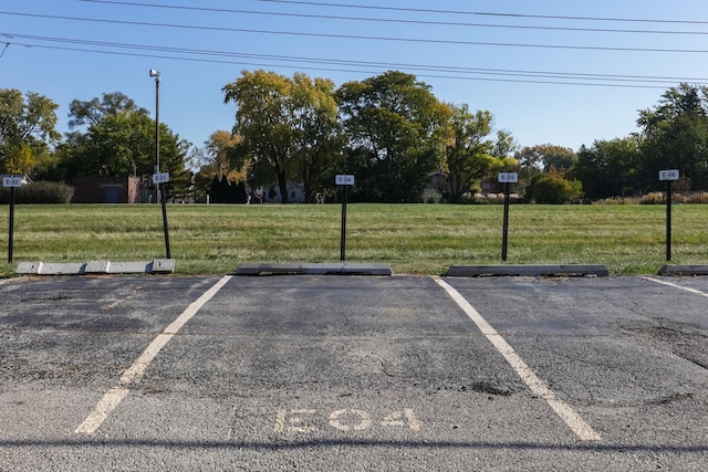 view of vehicle parking with a yard