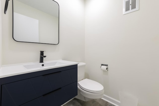 bathroom featuring wood-type flooring, vanity, and toilet