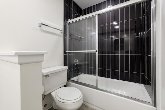 bathroom with bath / shower combo with glass door and toilet