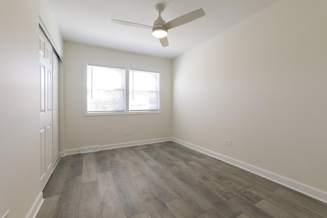 unfurnished room featuring ceiling fan and dark wood-type flooring