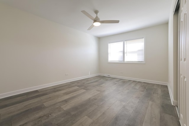 unfurnished room featuring ceiling fan and dark wood-type flooring