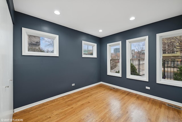 unfurnished room with hardwood / wood-style flooring