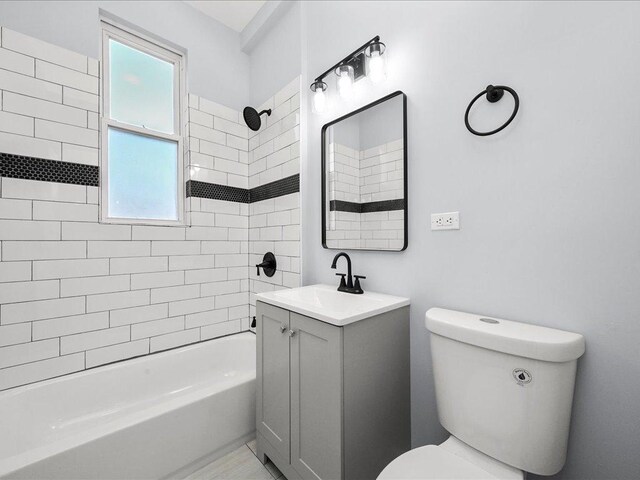 full bathroom with vanity, tiled shower / bath combo, and toilet