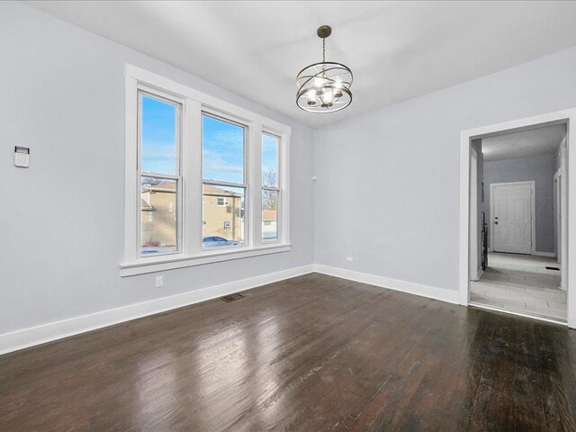 unfurnished dining area featuring dark hardwood / wood-style flooring and an inviting chandelier