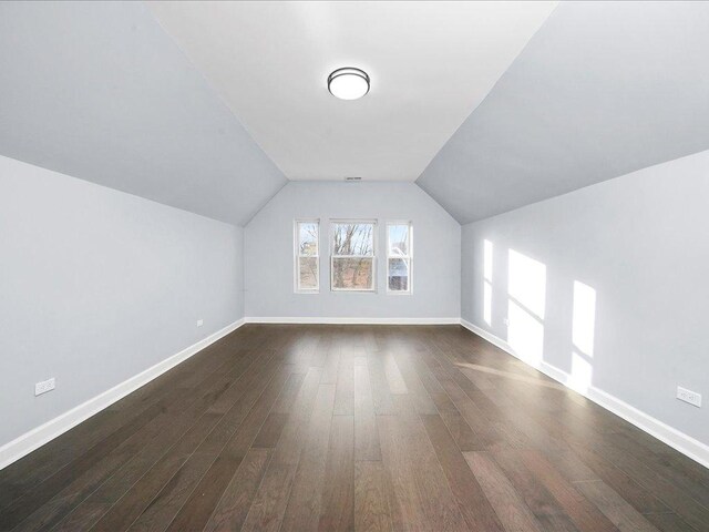 bonus room featuring dark wood-type flooring and vaulted ceiling