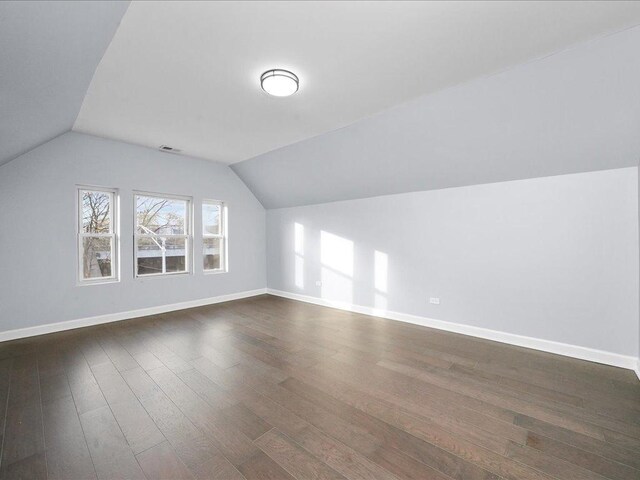 bonus room with dark wood-type flooring and lofted ceiling