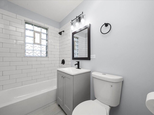 full bathroom featuring vanity, toilet, and tiled shower / bath