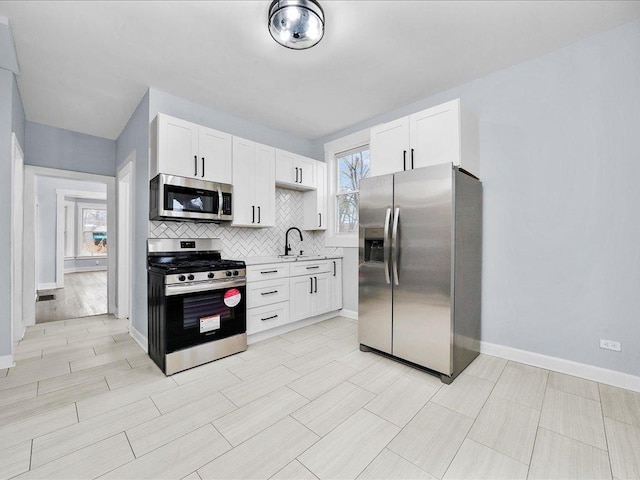 kitchen featuring a healthy amount of sunlight, white cabinetry, and stainless steel appliances