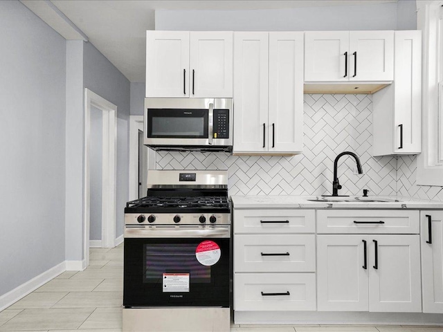 kitchen with white cabinets, backsplash, stainless steel appliances, and sink