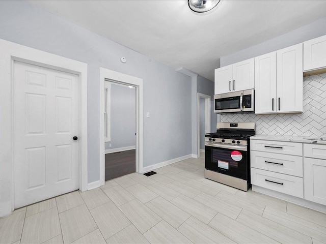 kitchen featuring backsplash, white cabinetry, and stainless steel appliances