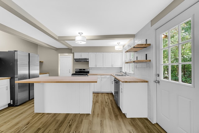 kitchen featuring a center island, white cabinets, butcher block countertops, light hardwood / wood-style floors, and stainless steel appliances