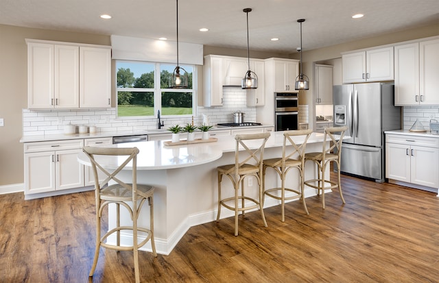 kitchen with a center island, white cabinetry, stainless steel appliances, and light hardwood / wood-style flooring