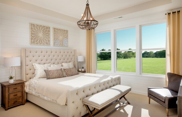 bedroom featuring a chandelier, light colored carpet, and wooden walls