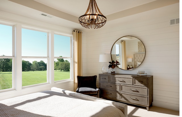 bedroom with an inviting chandelier, multiple windows, and wooden walls