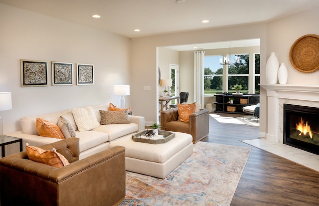 living room featuring a high end fireplace, hardwood / wood-style flooring, and an inviting chandelier