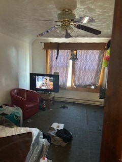 living room with a textured ceiling and ceiling fan