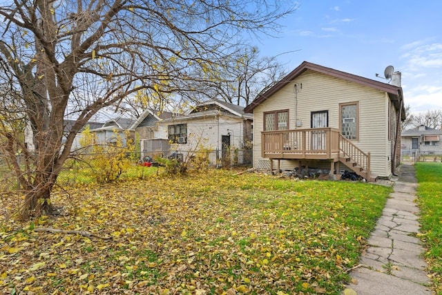 back of house with a deck and a yard