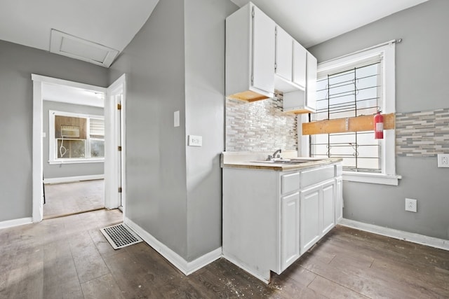 kitchen with tasteful backsplash, a wealth of natural light, and white cabinetry