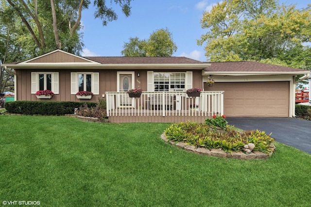 ranch-style home with a front yard, covered porch, a garage, and driveway