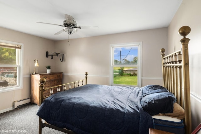 carpeted bedroom with baseboard heating, multiple windows, baseboards, and ceiling fan