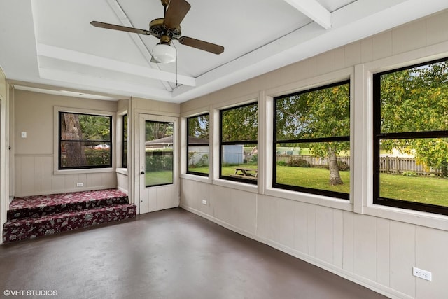 unfurnished sunroom with a ceiling fan and a tray ceiling