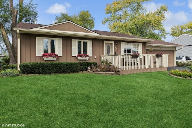 single story home with an attached garage, roof with shingles, a front yard, and board and batten siding