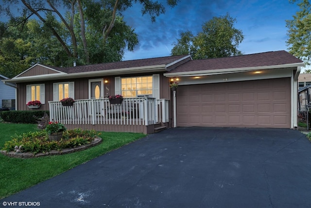 single story home featuring a garage, a porch, and driveway