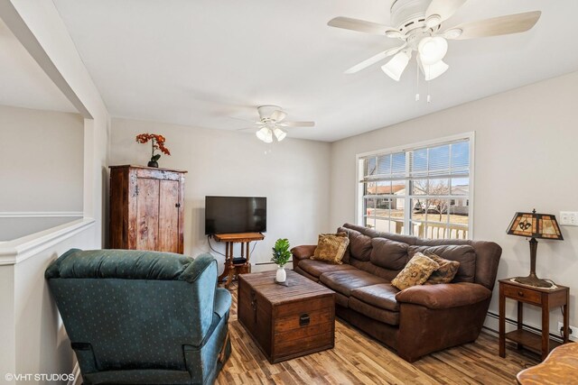 living area with a ceiling fan, light wood-style floors, and a baseboard radiator