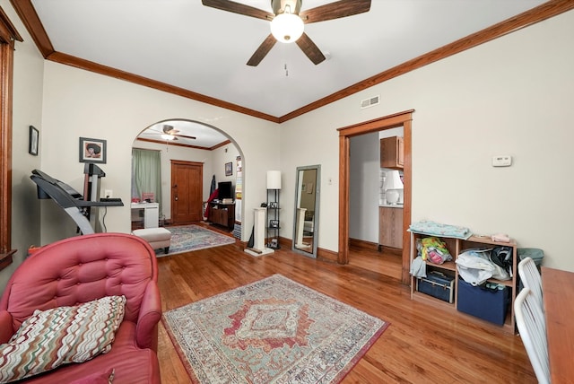 living room featuring ceiling fan, light hardwood / wood-style floors, and ornamental molding