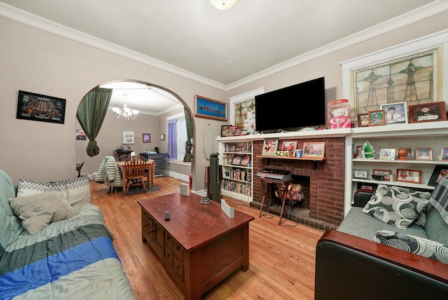 living room with ornamental molding, light hardwood / wood-style flooring, and a notable chandelier