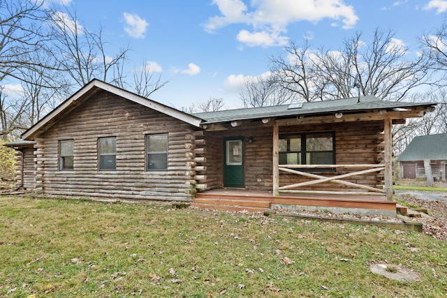 log cabin featuring covered porch and a front yard