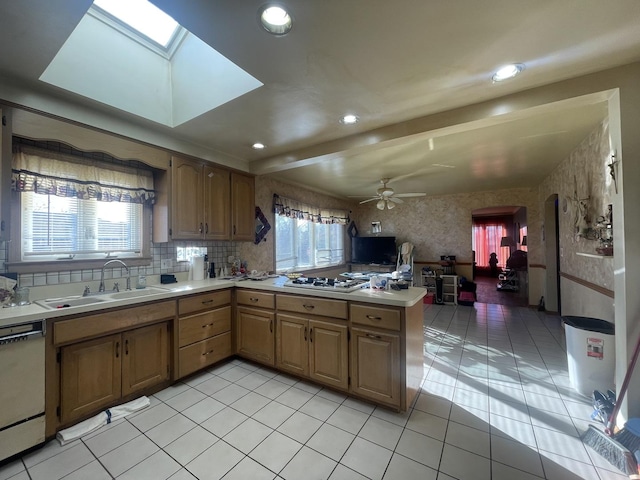 kitchen featuring sink, ceiling fan, light tile patterned floors, appliances with stainless steel finishes, and beamed ceiling