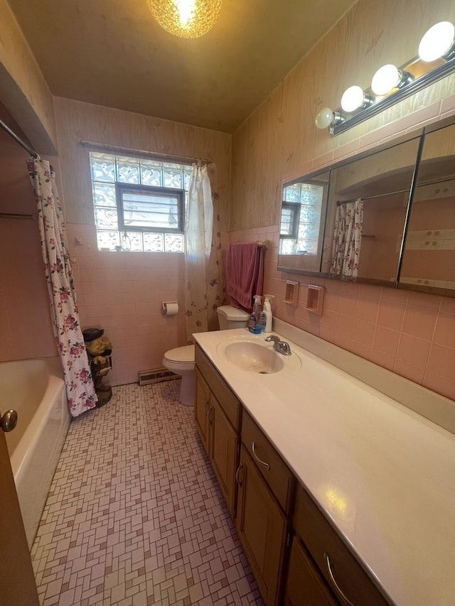 full bathroom with shower / bath combo with shower curtain, vanity, tile walls, and a healthy amount of sunlight