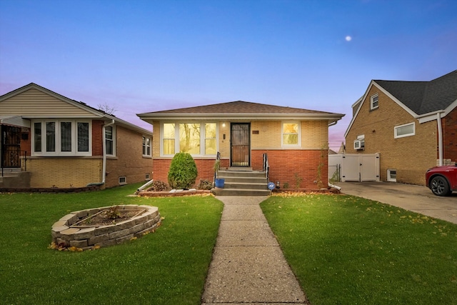 view of front of house featuring a lawn and an outdoor fire pit