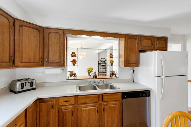 kitchen with decorative backsplash, sink, white refrigerator, dishwasher, and a chandelier