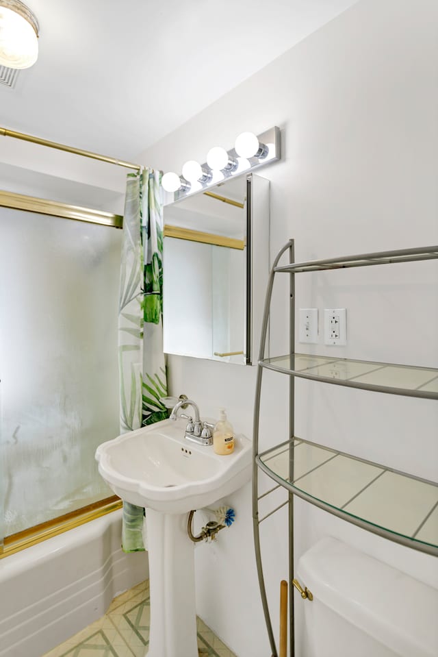 bathroom featuring toilet and shower / bath combo with shower curtain