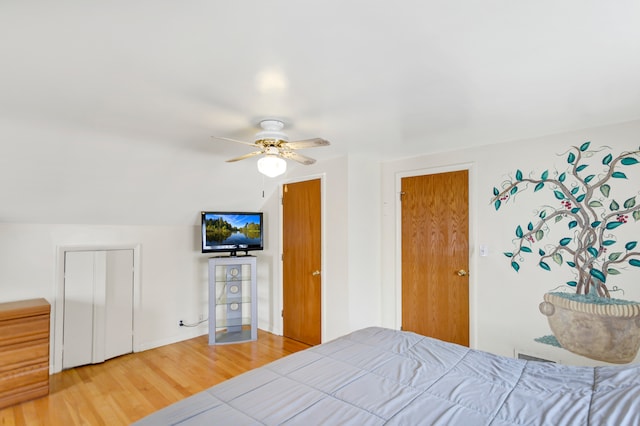 bedroom with ceiling fan, wood-type flooring, and lofted ceiling