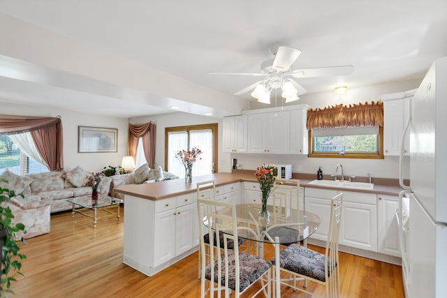 kitchen featuring white fridge, a healthy amount of sunlight, light hardwood / wood-style floors, and sink