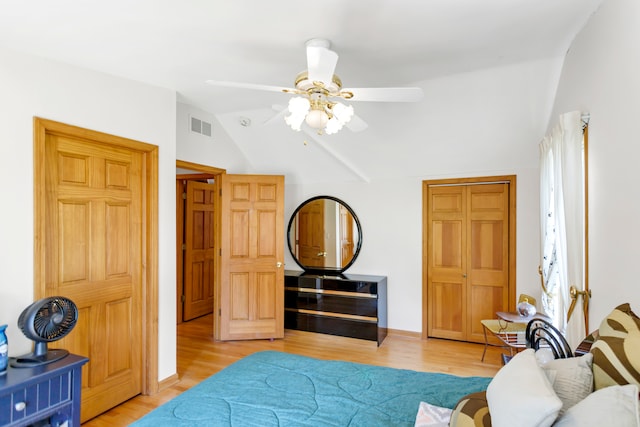 bedroom with ceiling fan, vaulted ceiling, and light wood-type flooring