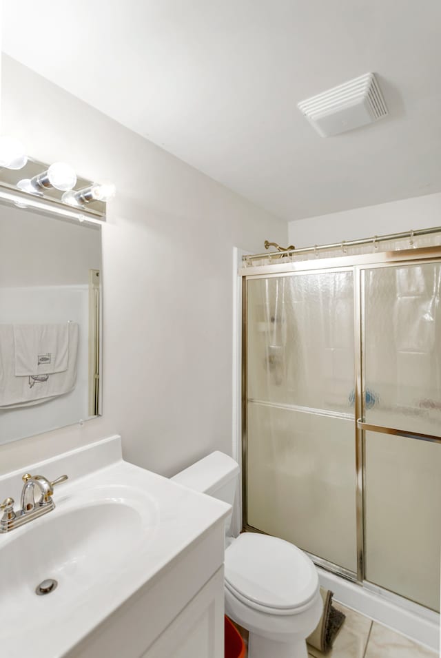 bathroom with toilet, vanity, tile patterned floors, and an enclosed shower