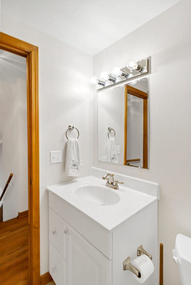 bathroom featuring hardwood / wood-style floors, vanity, and toilet