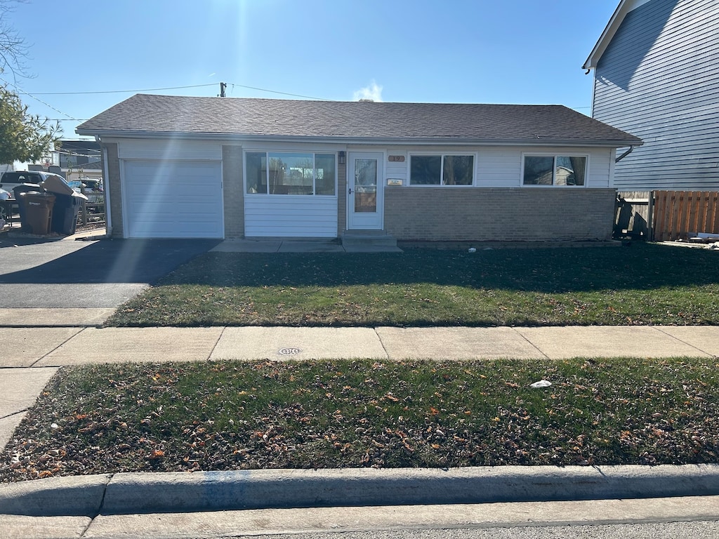 single story home featuring a front lawn and a garage