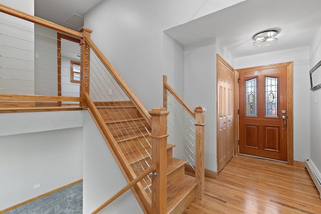 entrance foyer with light wood-type flooring and a baseboard heating unit