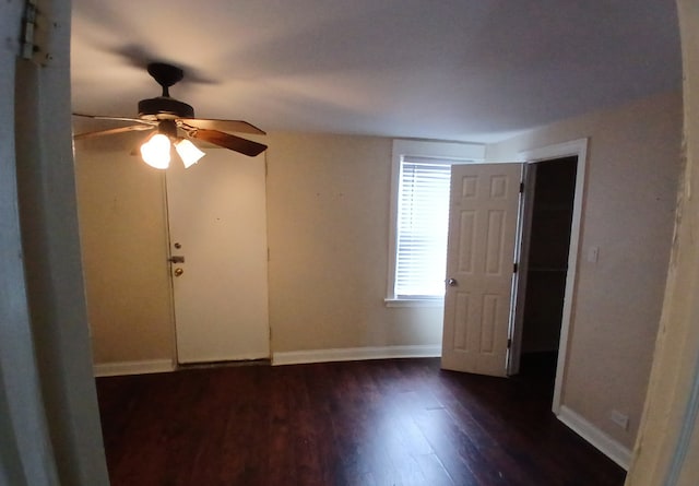 empty room with ceiling fan and dark hardwood / wood-style flooring