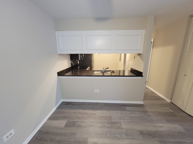 kitchen featuring stainless steel electric range oven, white cabinetry, sink, and wood-type flooring