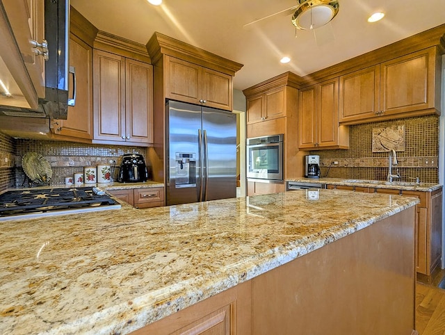 kitchen with light stone countertops, backsplash, stainless steel appliances, and sink