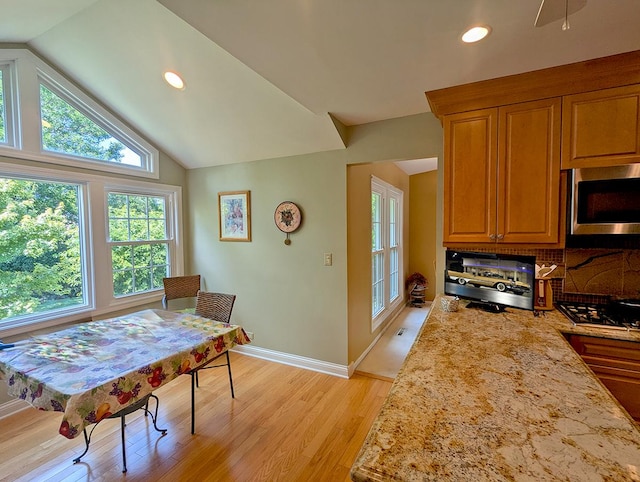 dining space featuring plenty of natural light, lofted ceiling, and light hardwood / wood-style flooring