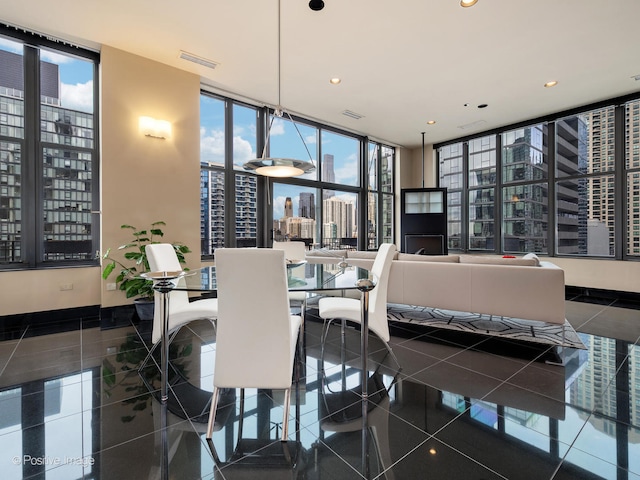 dining space with expansive windows and dark tile patterned flooring