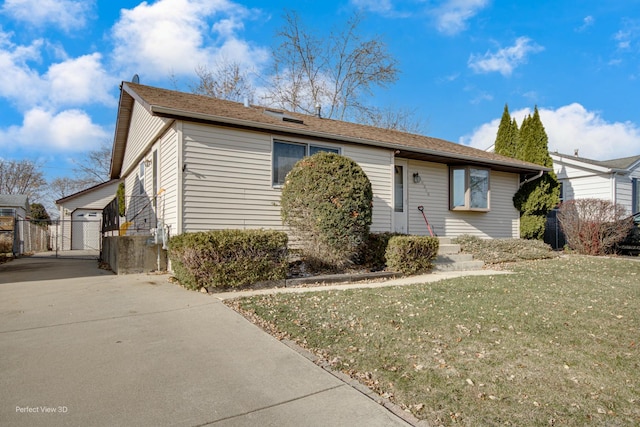 view of front of house featuring a garage, a front lawn, and an outdoor structure